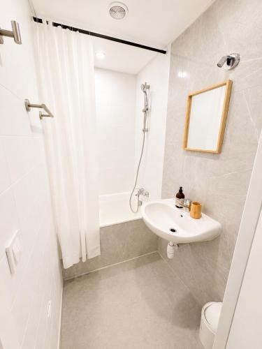 a white bathroom with a sink and a toilet at Le Lac Bleu - Sevrier in Sévrier