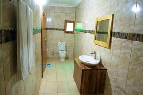 ein Badezimmer mit Waschbecken und Toilette in der Unterkunft Hôtel LEWI 2 Bouaké in Bouaké