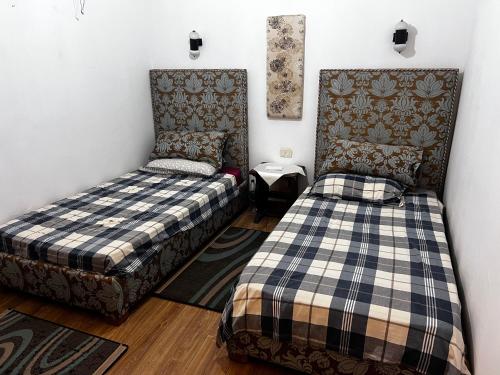 a room with two beds and a chair at Dar Cirta in Sicca Veneria