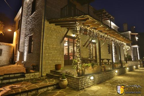 a building with christmas lights on the side of it at Arkefthos Mountain Hotel in Papigko