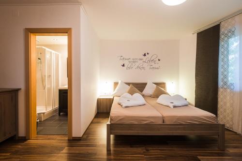 a bedroom with a bed with two pillows on it at Pension Julia & Haus Elisabeth - Wallner's Hofheuriger & Weinhof in Mörbisch am See