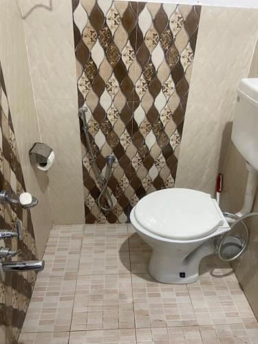 a bathroom with a toilet and a shower at Ahmed Lodge in Harganyiwan