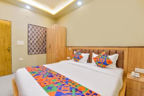 a bedroom with a large white bed with colorful pillows at FabHotel The Fort - Near Amber Palace in Jaipur
