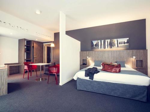 a hotel room with a bed and a table and chairs at Mercure Saint Malo Balmoral in Saint Malo