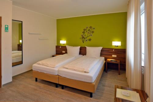 1 dormitorio con cama y pared verde en Hotel L' Angolo, en Trier