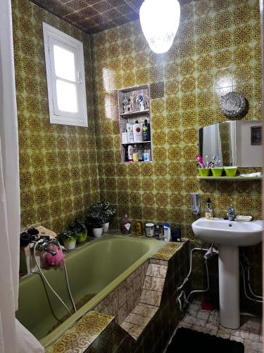 a bathroom with a green tub and a sink at Dar Cirta in Sicca Veneria