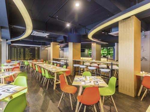 a dining room with tables and chairs at Ibis Styles Bangkok Sukhumvit 50 in Bangkok