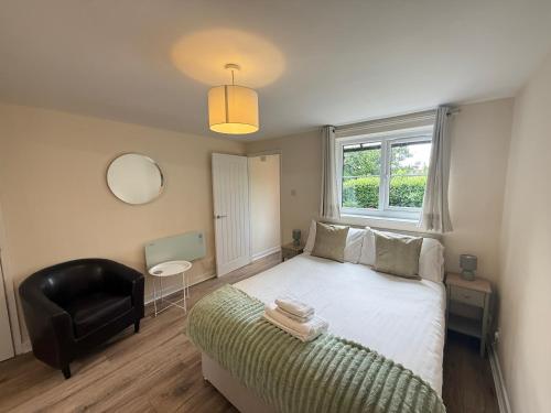 a bedroom with a bed and a chair and a window at Modern studio flat in Wellington, Telford in Wellington