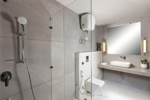 a bathroom with a shower and a toilet and a sink at Hotel Delhi 37 by Star Group in New Delhi