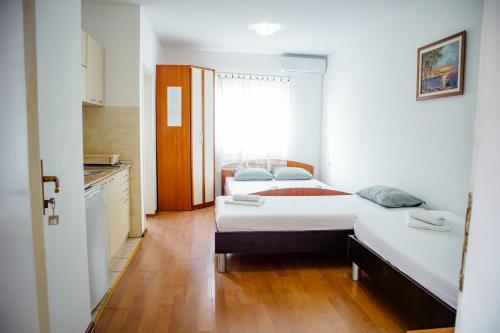 a small room with two beds and a kitchen at Apartmani Grbović in Čanj