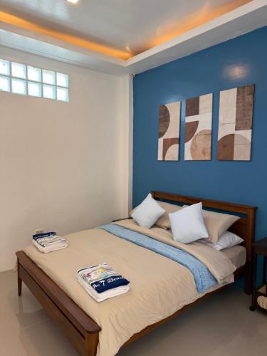 a bedroom with a bed with a blue wall at The Coast By RAD in Talisay