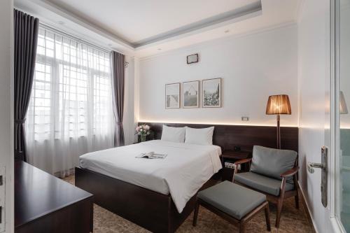 a hotel room with a bed and a chair at 그레이스 호텔 Grace Hotel & Residence in Hanoi