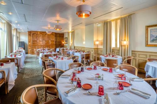 ein Esszimmer mit weißen Tischen und Stühlen in der Unterkunft Hotel Le Viscos in Saint-Savin