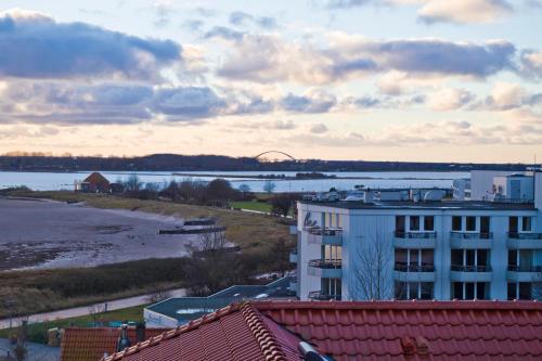 a view of a body of water and a building at Turm-Appartement Strandburg in Fehmarn