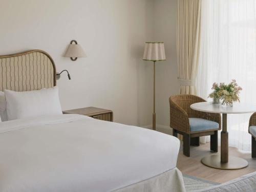 a hotel room with a bed and a table and chairs at Elysium Noosa Resort - MGallery Collection in Noosa Heads