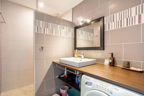 a bathroom with a sink and a washing machine at L'Esprit Cap Coz in Fouesnant