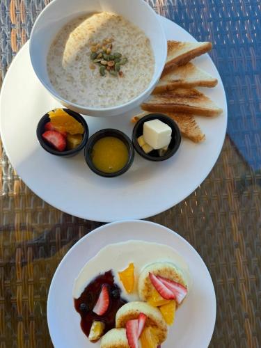 two plates of food with a bowl of soup and bread at Dostar Beach Hotel - Достар Жағажай Қонақүйі in Aktau