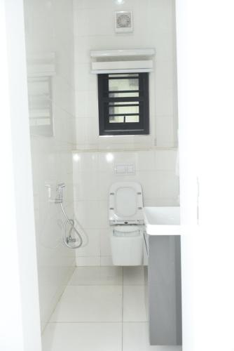 ein weißes Badezimmer mit Toilette und Waschbecken in der Unterkunft White Pole Apartments in Abuja