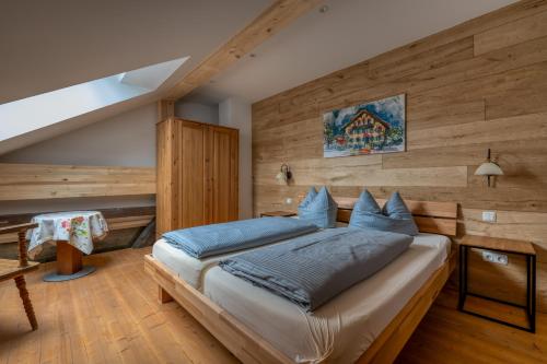 a bedroom with a large bed with a wooden wall at Zum Kirchenbauer in Oberammergau
