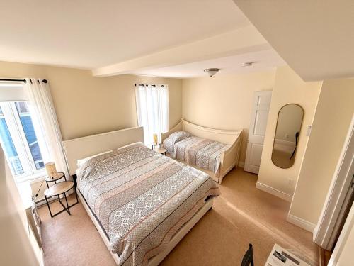 a bedroom with two beds and a mirror at Gîte de la vallee in Coaticook