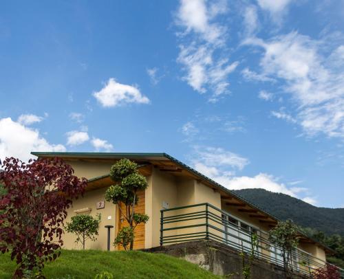 a house on a hill with a blue sky at Rakkh Resort, a member of Radisson Individuals Retreats in Pālampur