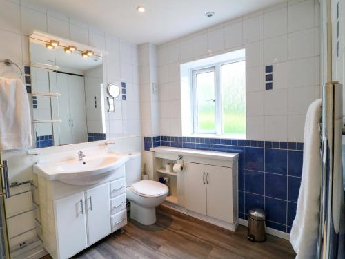 a bathroom with a sink toilet and a mirror at The Chimes in Castleton
