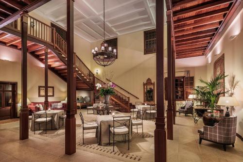 a lobby with tables and chairs and a staircase at Hacienda del Conde member of Meliá Collection - Adults Only in Buenavista del Norte