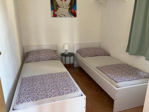 two beds in a room with a painting on the wall at Robinson Marko in Gdinj