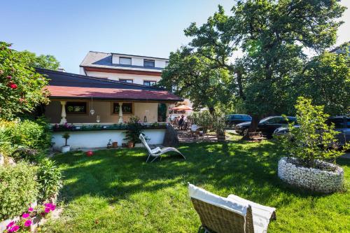 a yard with some chairs and a house at Pension Julia & Haus Elisabeth - Wallner's Hofheuriger & Weinhof in Mörbisch am See