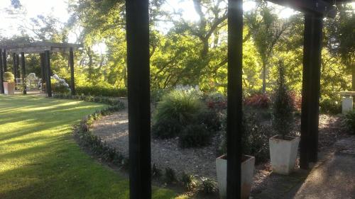 a garden with a gazebo and some plants at Cambridge Coach House in Cambridge