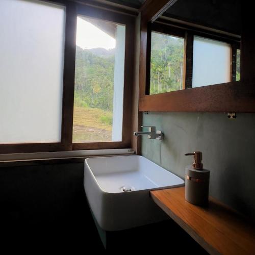 a bathroom with a white sink and two windows at Visari Fall Villa Ella in Ella