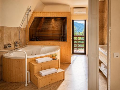 a bathroom with a tub and a large window at Ioana Boutique Hotel in Sinaia