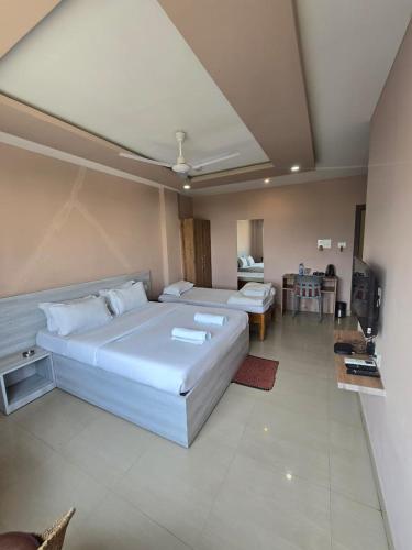 a bedroom with a large bed and a living room at SILVER REGENCY in Guwahati