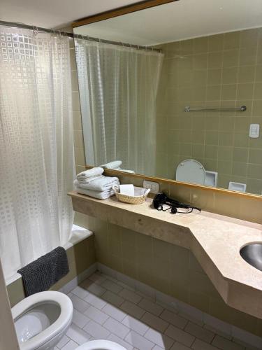 a bathroom with a toilet and a sink and a mirror at APART CyJ OBELISCO in Buenos Aires
