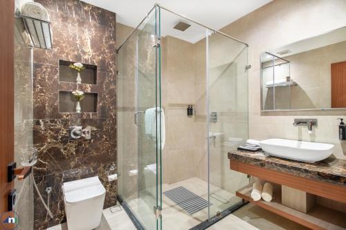 a bathroom with a shower and a toilet and a sink at Northern Residency in Srinagar
