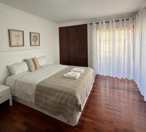 a bedroom with a large bed and a large window at Praia - Mar in Ovar