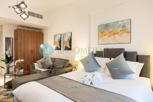 a bedroom with a bed and a living room at Bloomfields Studio in Oasis Masdar in Abu Dhabi