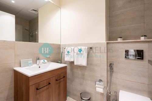 a bathroom with a sink and a shower and a mirror at Bloomfields Studio in Oasis Masdar in Abu Dhabi