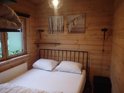 a bedroom with a bed in a log cabin at Huis H8 in Epe