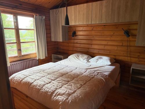 a bedroom with a bed with a wooden wall at Baron in Beffe