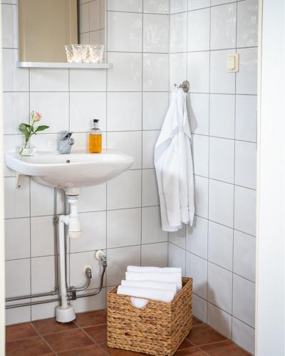a bathroom with a sink and a basket with towels at Nordic Lapland Frevisören in Båtskärsnäs