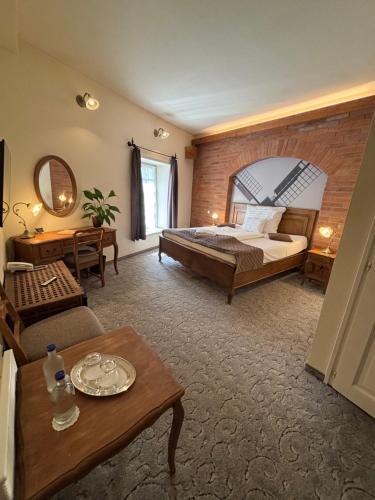 a hotel room with a bed and a table at Malom Hotel in Debrecen