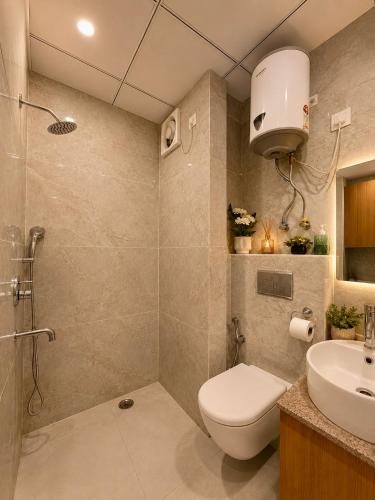 a bathroom with a shower and a toilet and a sink at The Amberwood Escape in Greater Noida