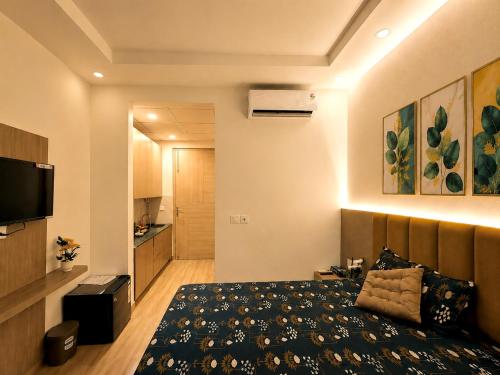 a bedroom with a bed and a flat screen tv at The Amberwood Escape in Greater Noida
