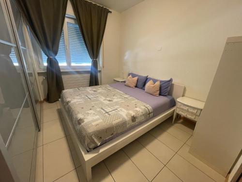 a bedroom with a bed with blue pillows and a window at Balerna Swiss Apartment by RentuGoo Travel in Balerna