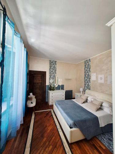 a bedroom with a large bed with a blue blanket at Dietro al Corso in LʼAquila