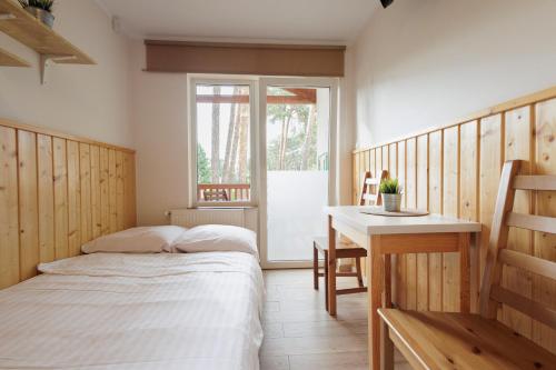 a bedroom with two beds and a table and a window at Relaks Boszkowo in Boszkowo-Letnisko