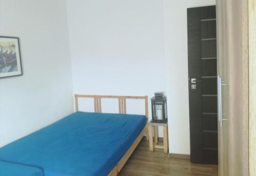 a bedroom with a blue bed and a black closet at Apartament Stogi in Gdańsk