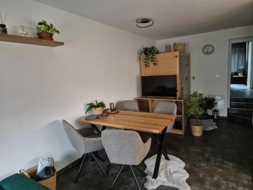 a dining room with a wooden table and chairs at Apartmán U Lanovky in Kramolín