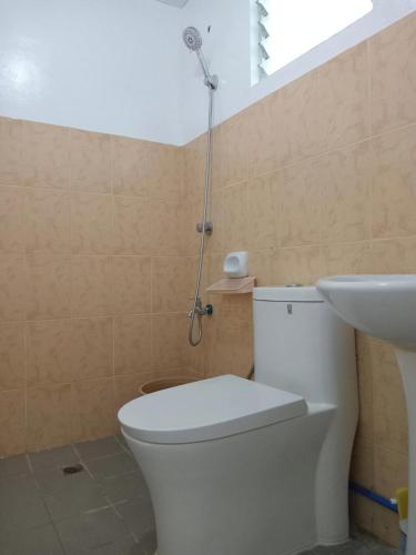 a bathroom with a toilet and a sink and a shower at 3G's & C Transient House Calapan in Camilmil